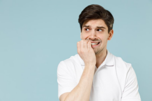 Man nervously biting his fingers because he really doesn’t want dry socket