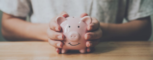 Close up of someone holding a smiling piggy bank